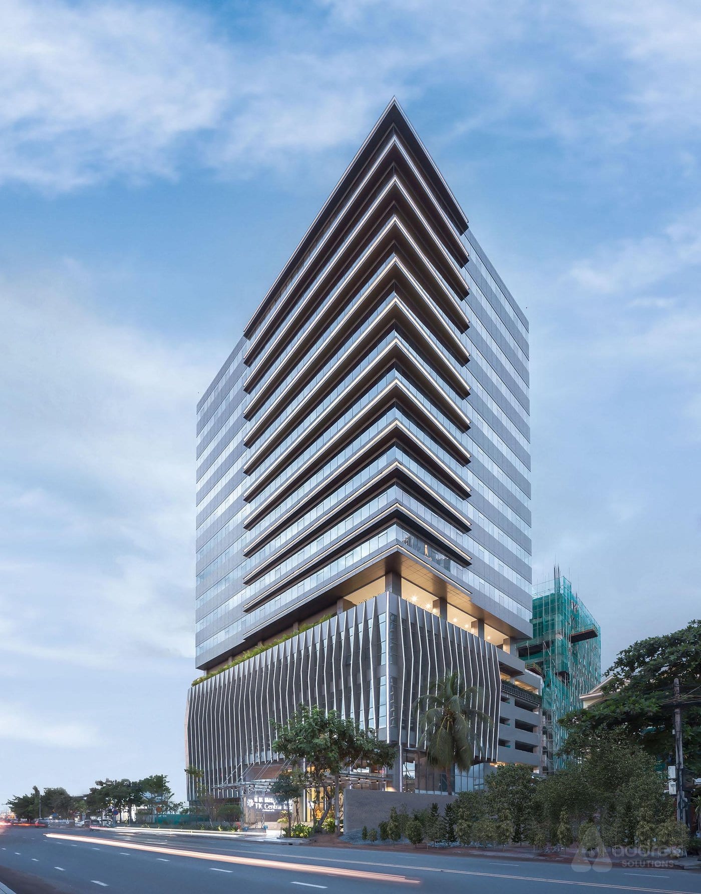 Modern commercial retail tower with illuminated ground-floor storefronts